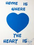 Ein blau ausgemaltes Herz mit dem Schriftzug Home is where the Heart is drumherum