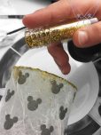 Goldenes Glitzerpulver wird aufgetragen
