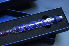 Zauberstab aus Glas, der mit einem blauen Zauberhut verziert ist
