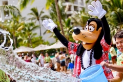 Goofy im Hawaiihemd und ein CM planschen mit Wasser