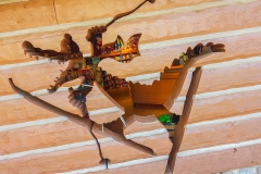 Holzwand mit einem Loch in Form eines Aligatoren mit Skiern