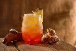 Orange-Roter Cocktail mit einem Stück Ananas am Glasrand Orange-Roter Cocktail mit einem Stück Ananas am Glasrand