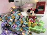 Minnie Mouse Stofftier sitzt vor Nähmaschine