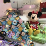 Minnie Mouse Stofftier sitzt vor Nähmaschine