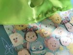Grüner Stoff wird auf TsumTsum Stoff festgesteckt
