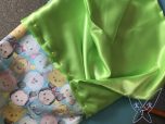 Grüner Stoff ist mit Stecknadeln am TsumTsum Stoff befestigt