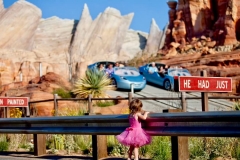 Ein kleines Mädchen beobachtet die Autos in der Attraktion Radiator Springs Racers