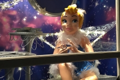 Sitzende Tinkerbell hält einen Stern in Händen