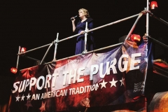 Bühne mit einer Sängerin, dazu das Plakat 'Support the Purge'
