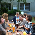 Konferenzteilnehemr sitzen an einem Tisch im Biergarten