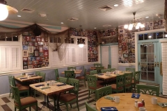 Gastraum von Olivia's Restaurant mit Wänden, an denen zahlreiche gerahmte Fotografien hängen