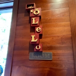 Wandbild mit den Buchstaben Olelo handgeschnitzt