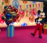 Mickey Mouse posiert mit Geschenken und Luftballons Mickey Mouse posiert mit Geschenken und Luftballons