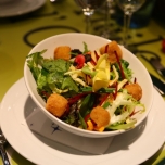 Die Vorspeise: Salat mit Käsewürfeln in einem Schälchen angerichtet