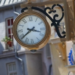 Uhr mit römischem Ziffernblatt, die an einer Hauswand befestigt ist