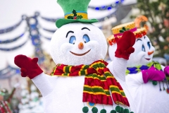 Winkender Schneemann mit grünem Hut, rotem Schal und roten Handschuhen
