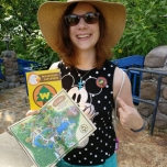 Dörthe zeigt Plan, Heft und Sticket der Wilderness Explorer