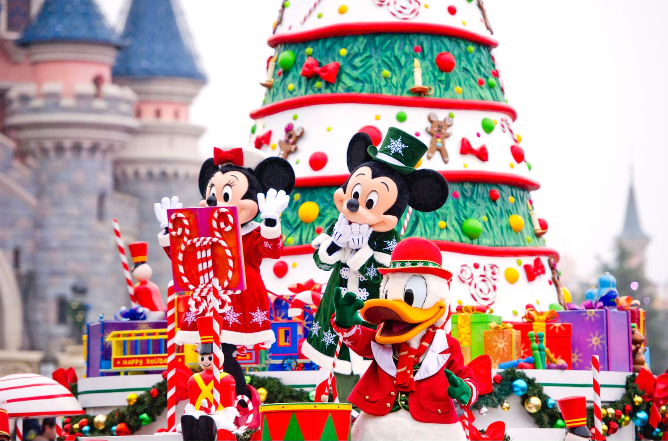 Weihnachtsparade mit Mickey, Minnie & Donald auf einem Wagen mit Weihnachtsbaum