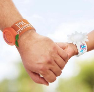 ein Erwachsener und ein Kind halten sich an den Händen, beide tragen Magic Bands