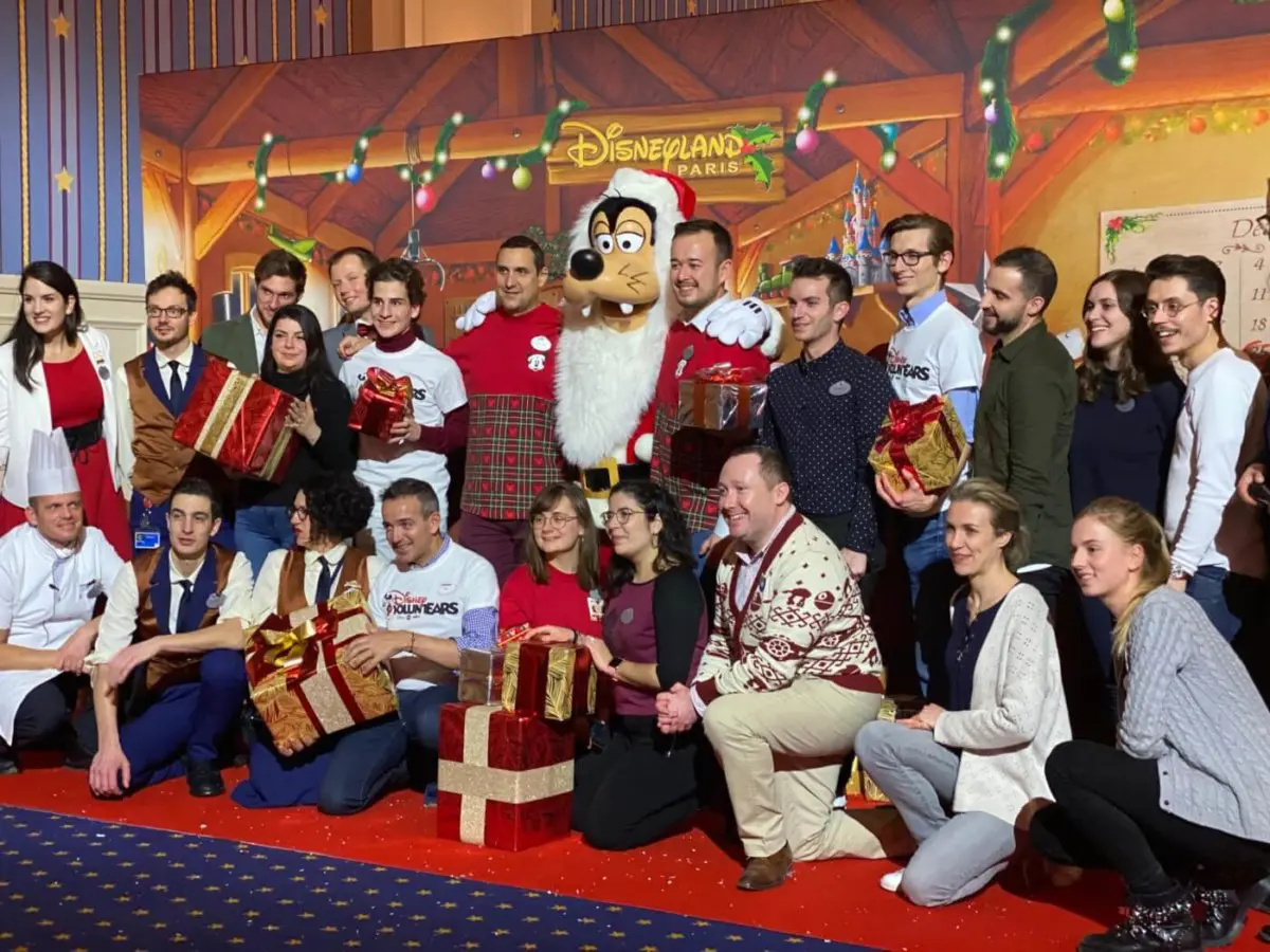 Gruppenfoto mit Santa Goofy Disney Voluntears mit Geschenken der Party für einen guten Zweck