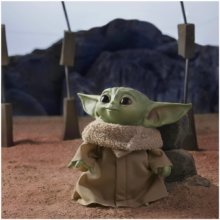 The Child als Plüschfigur steht vor einem Stein auf dem Planeten Arvala-7