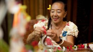 Aunty Kau'i aus dem Polynesian Village Resort beim Erstellen einer Lanai-Blumenkette