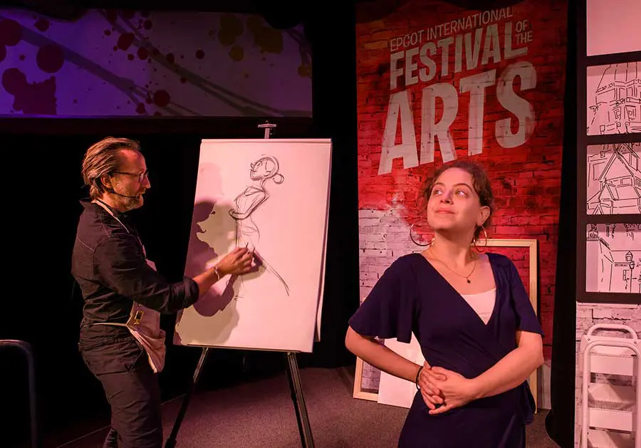 Künstler zeichnet Portrait Ein Künstler zeichnet beim Festival of the Arts eine junge Frau, die für ihn posiert