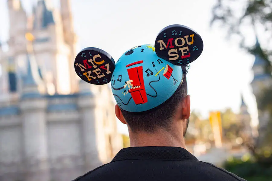 Mickey Mouse Hut Ein Mann, der von hinten zu sehen ist, trägt einen Mickey Ear Hat-Hut vor dem Cinderella Castle