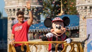 Patrick Maholmes und Mickey Maus winken von einem Wagen bei der Parade im Magic Kingdom