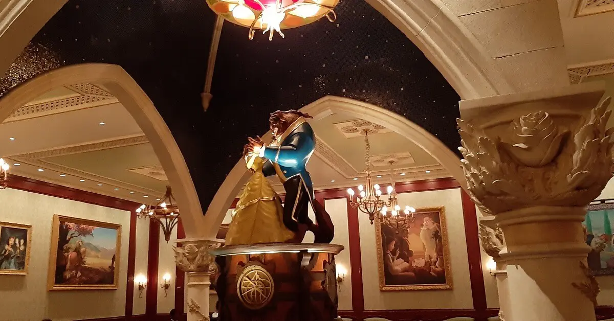 Blick in die Bildergalerie im Be Our Guest Restaurant und auf die in der Mitte des Raums stehende große Spieluhr