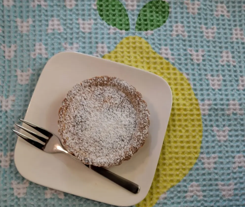 Teller mit Italian Lemon Tart Eine kleine Zitronentarte auf einem Tellerchen mit einer Kuchengabel