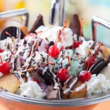 Eine große Schale ist mit verschiedenem Speiseeis, Sahne und verschiedenen Toppings gefüllt