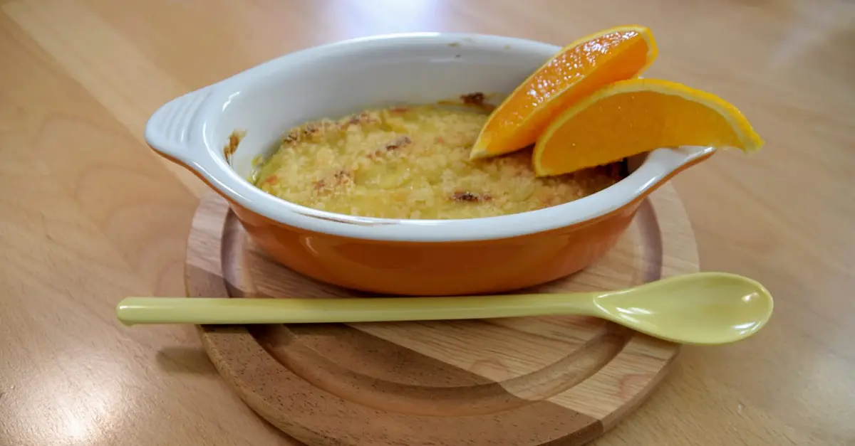In einem feuerfesten Schälchen sind eine Portion Crema Catalana und zwei Orangenspalten zu sehen