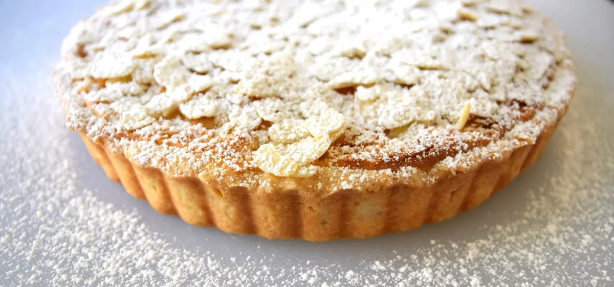 Apple Pie mit Puderzucker Auf einem Schneidebrett liegt der fertige und mit Puderzucker bestäubte Apple Pie