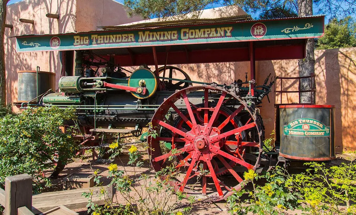 Dampfmaschine in Frontierland Ein alter Dampftraktor steht abseits des Weges zwischen den Pflanzen.
