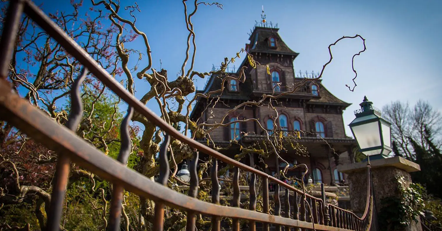 Das Spukhaus Phantom Manor in Disneyland Paris mit einem rostigen Zaun im Vordergrund