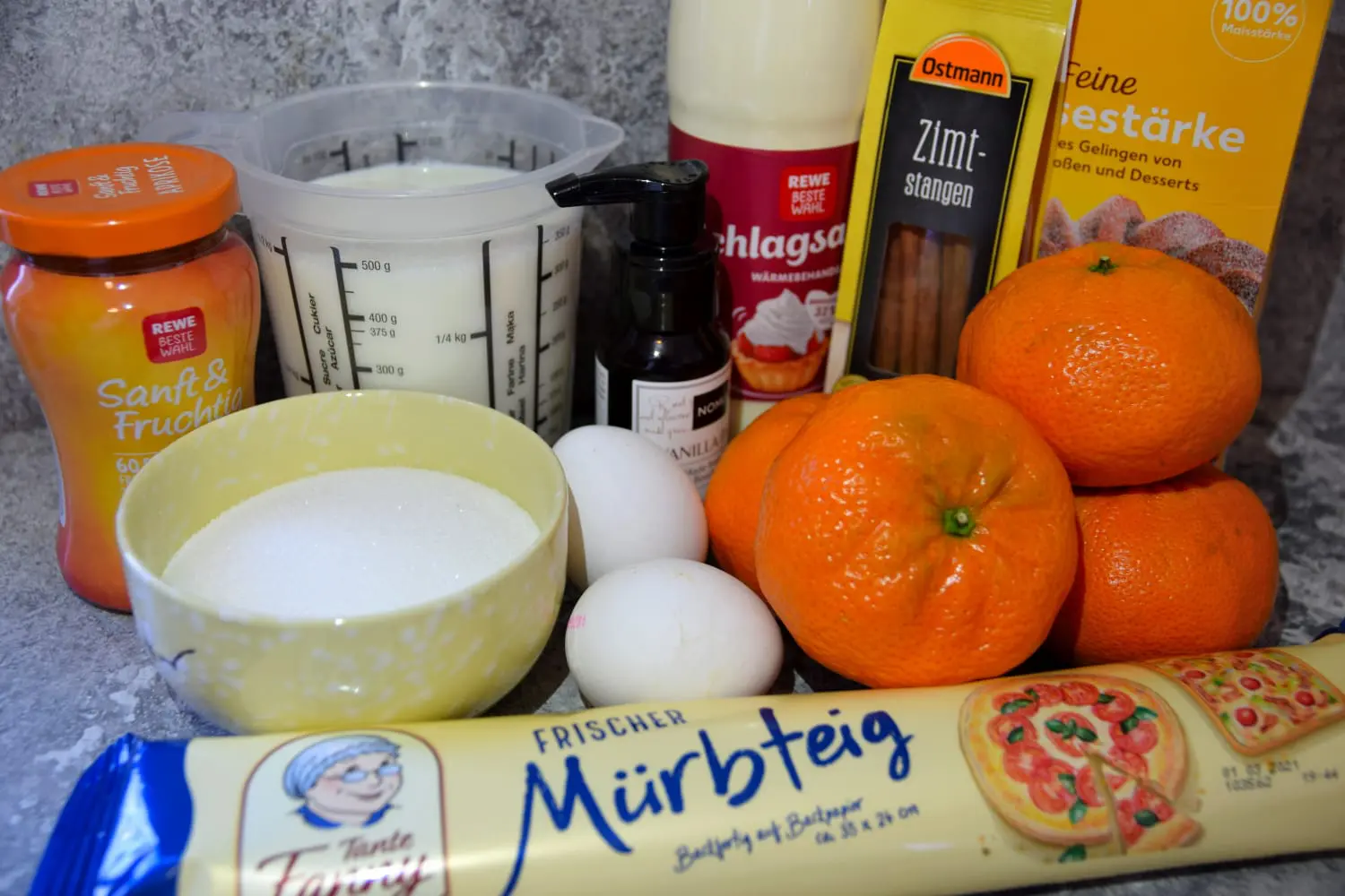 Zutaten für Melktert In einer Küche liegen alle für die Melktert benötigten Zutaten wie Mandarinen, Mürbeteig und Sahne