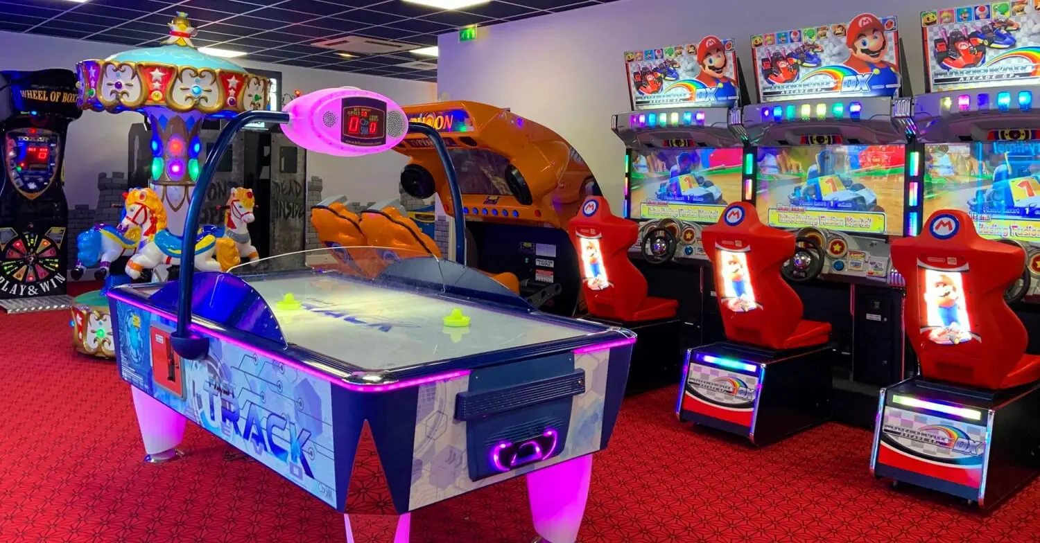 Ein Foto zeigt das Innere einer Video Game Arcade in Disneyland Paris mit verschiedenen Videospiel-Automaten und einem Airhockey-Tisch