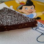Ein Stück Schokoladen-Haselnuss-Kuchen auf einem Teller mit Pinocchio-Motiv