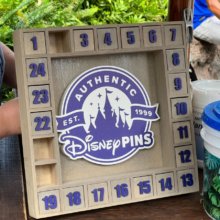 Ein quadratisches Holzbrett mit Fächern und Nummern für das Mystery Pin Trading in Disney's Animal Kingdom