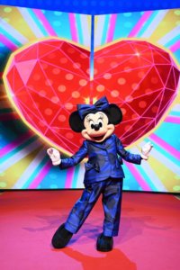 Fashionista Minnie Mouse im Hosenanzug posiert auf dem roten Teppich vor einem Bildschirm
