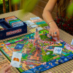 Disneyland Paris Monopoly Spielbrett mit Spielern am Tisch
