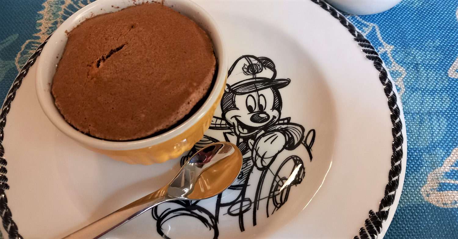 Schokoladensouffle in einem Förmchen auf einem Teller mit Mickey Mouse Motiv