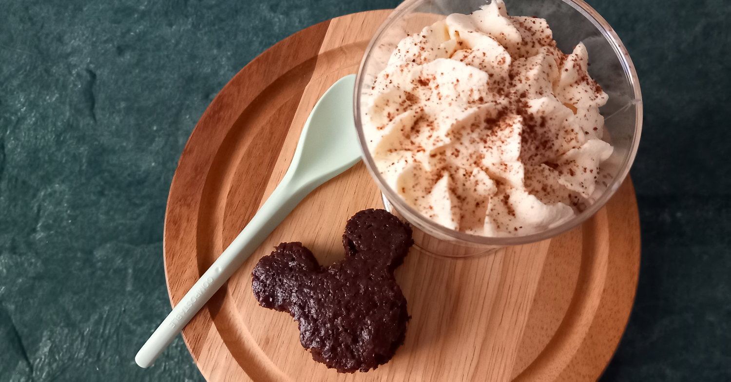 Dessert in einem Glas mit einem Löffel und einem kleinen Küchlein in Mickey Mouse Form