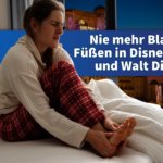 Eine Frau hält sich im Bett sitzend die schmerzenden Füße. Sie hat unsere Tipps zu Nie mehr Blasen an den Füßen in Disneyland Paris und Walt Disney World wohl nicht befolgt