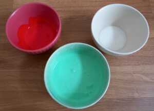 Drei Schälchen mit Royal Icing in verschiedenen Farben