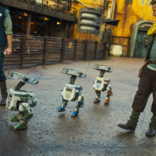 Drei BD Droids laufen mit zwei Cast Membern durch Galaxy's Edge