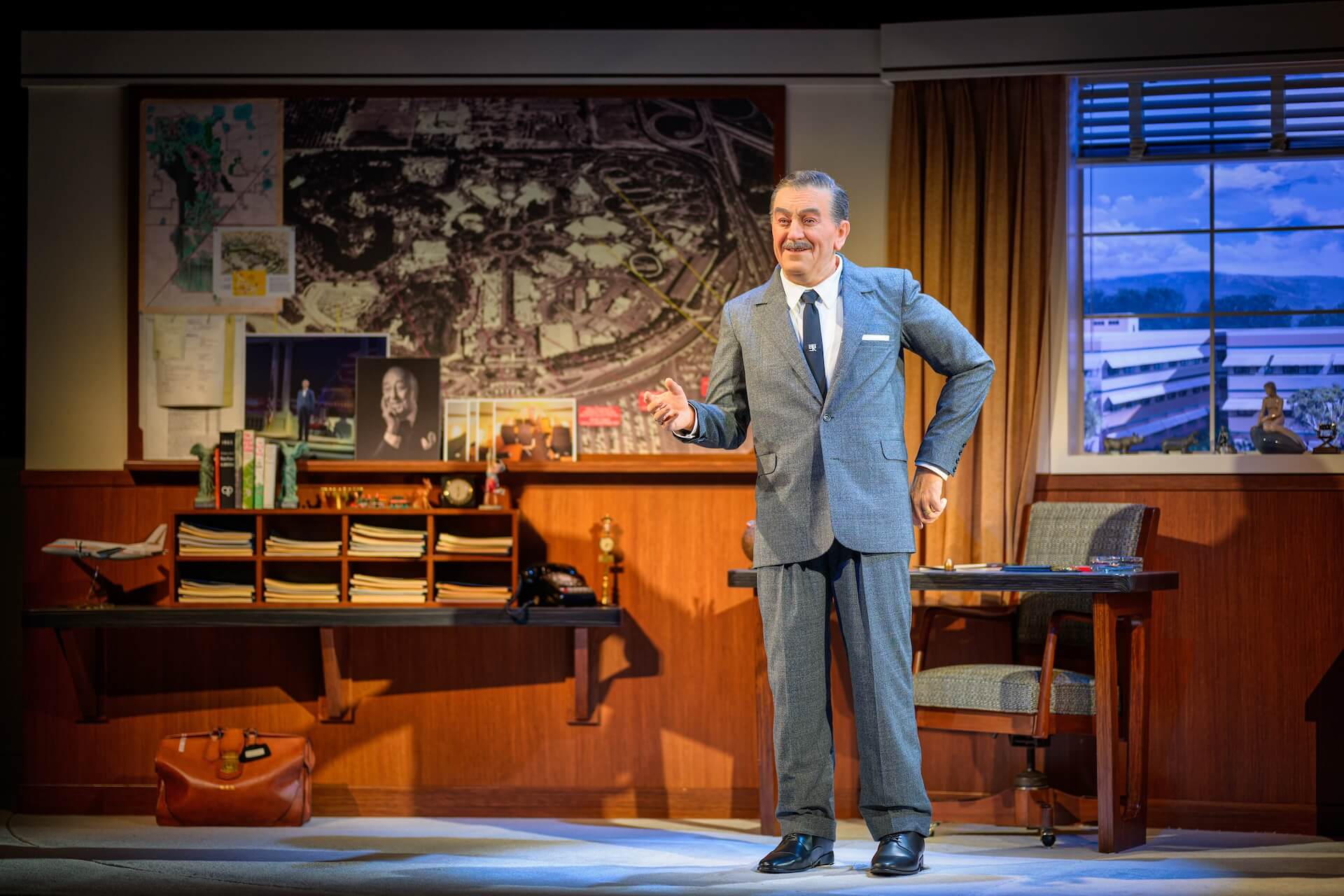 Wald Disney Animatronic steht vor der Karte des Disneyland Parks