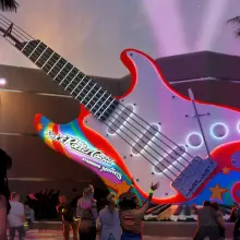 Konzeptzeichnung mit riesiger E-Gitarre vor dem Gebäude, die in psychedelischen Farben leuchtet