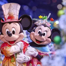 Mickey Mouse und Minnie Mouse Arm in Arm in weihnachtlichen Outfits